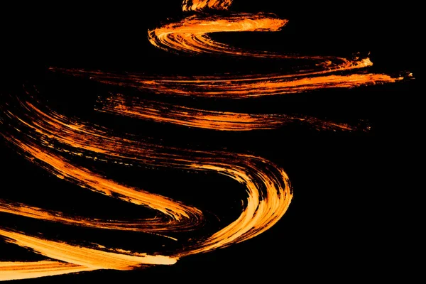 Abstract acrylic orange paint strokes on black background