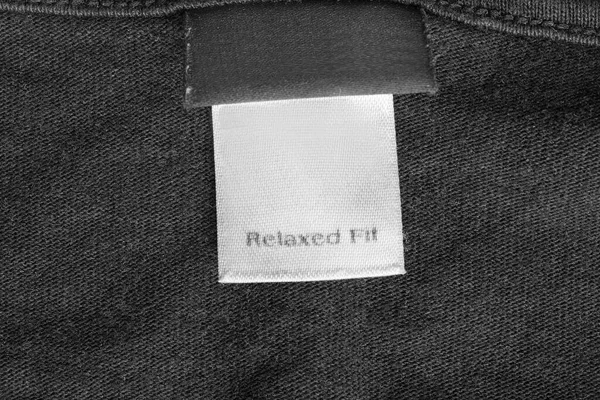 Etiqueta Ropa Dice Ajuste Relajado Sobre Fondo Textil Negro — Foto de Stock
