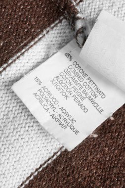 Örgü tekstil arka planında farklı dillerde kumaş kompozisyon giyim etiketi