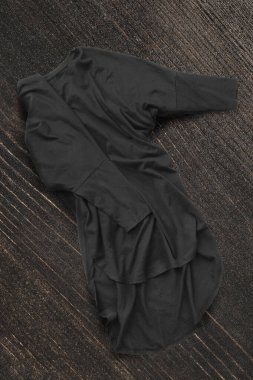 Koyu kahverengi ahşap arka planda buruşuk siyah gömlek.