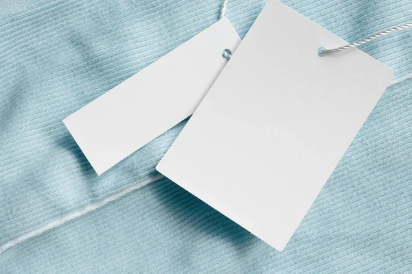 蓝色纺织品背景上的空白服装标签 免版税图库图片