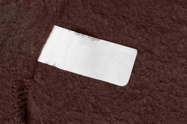 Etiqueta Ropa Blanco Sobre Fondo Textil Marrón — Foto de Stock