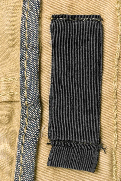 Sarı Tekstil Arka Planında Boş Tekstil Kıyafet Etiketi — Stok fotoğraf