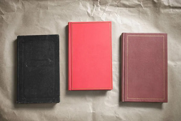 Three books with blank cover on craft paper background