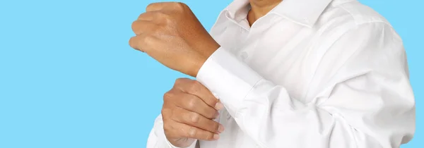 Zbliżenie Biznesmena Zapinającego Się Rękaw Swojej Białej Koszuli Odizolowaną Niebieskim — Zdjęcie stockowe