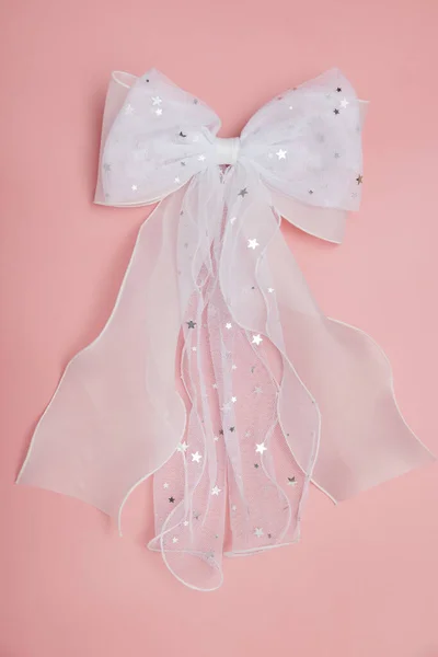 Beautiful hair bow for girls. Fashion accessory for girls hair on pink background.
