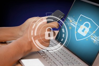 Akıllı telefon ve bilgisayar bilgisayarı kullanan genç bir adam. Siber internet güvenlik sistemi. Simge güvenlik teknolojisini bilgisayar ekranına kilitle.
