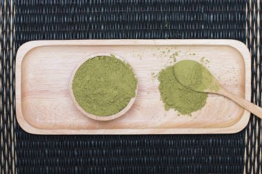 Tahta tepside, paspasın üzerine konmuş toz yeşil çay..