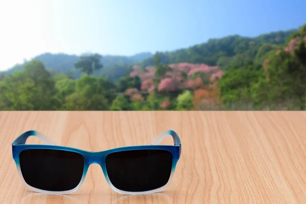 Sonnenbrille Auf Tisch Mit Naturhintergrund — Stockfoto