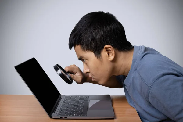 Joven Observando Portátil Con Lupa Aislada Sobre Fondo Gris — Foto de Stock