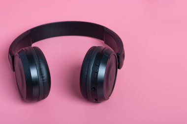Pembe arka planda siyah kulaklıklar. Müzik konsepti