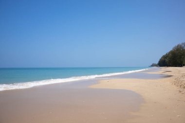 Güzel bir sahil, turkuaz okyanus suyu ve güneşli bir günde mavi gökyüzü. Yaz tatili için arka plan.