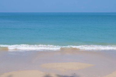 Güzel bir sahil, turkuaz okyanus suyu ve güneşli bir günde mavi gökyüzü. Yaz tatili için arka plan.