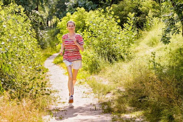 Ανώτερος γυναίκα που τρέχει στο δάσος — Φωτογραφία Αρχείου