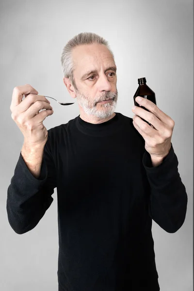 Hombre bebiendo jarabe para la tos —  Fotos de Stock