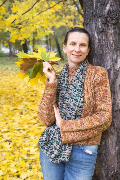 Frau pflückt Blätter im Herbst — Stockfoto