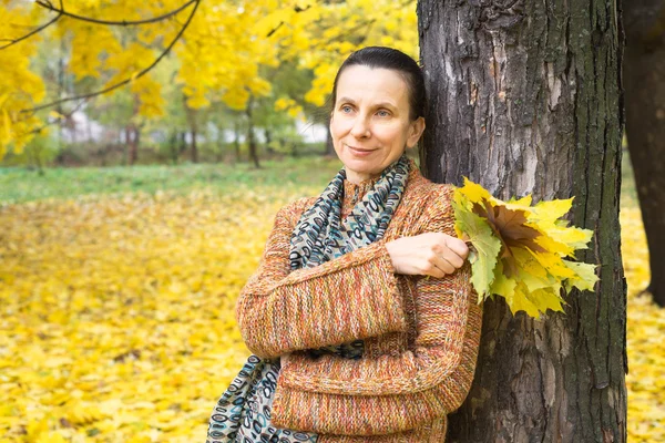 Frau pflückt Blätter im Herbst — Stockfoto