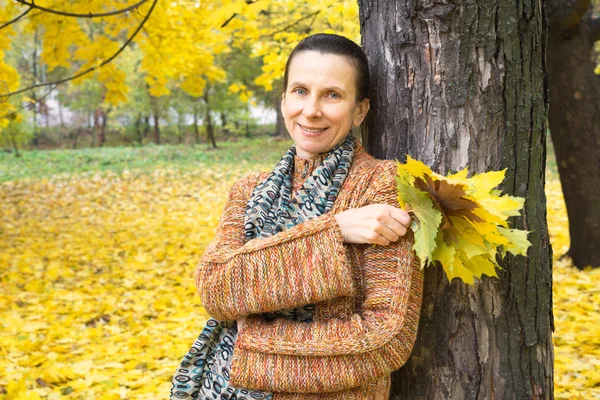 Frau pflückt Blätter im Herbst — Stockfoto