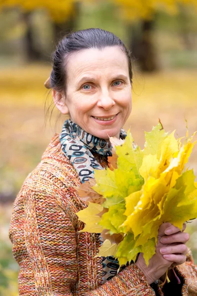 Frau pflückt Blätter im Herbst — Stockfoto