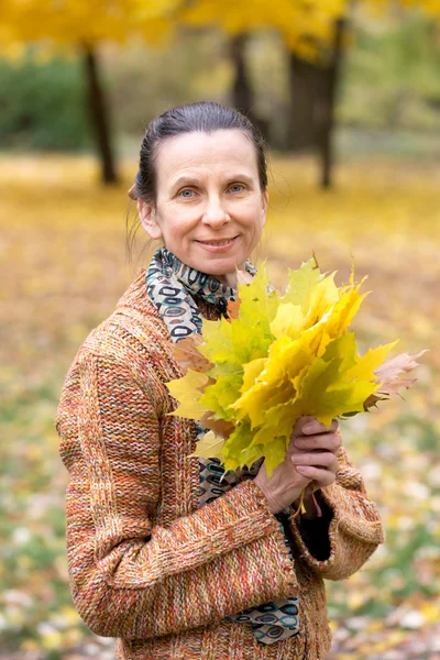 Frau pflückt Blätter im Herbst — Stockfoto