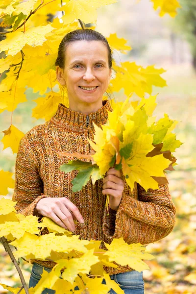 La mujer recogiendo hojas en otoño —  Fotos de Stock