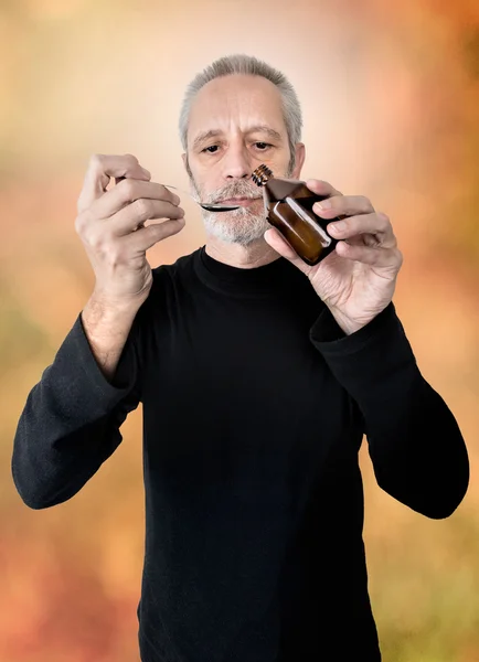 Homem bebendo xarope de tosse — Fotografia de Stock