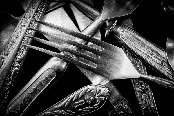 Abstract black and white photo of mixed silver forks, spoons and — Stock Photo, Image