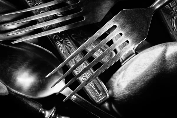 Abstract black and white photo of mixed silver forks, spoons and — Stock Photo, Image