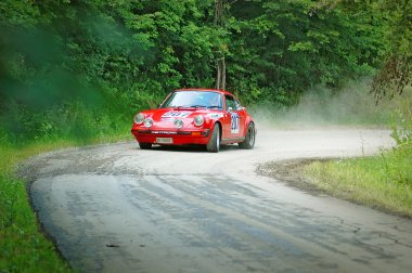 Unidentified drivers on a red vintage Porsche 911 S racing car