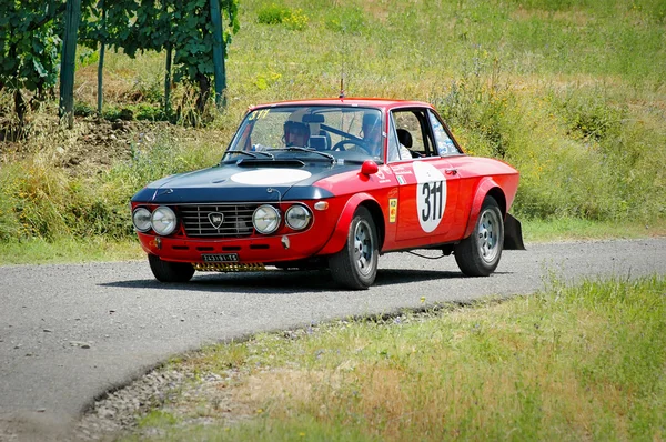Unidentified drivers on a black and red vintage Lancia Fulvia racing car — 스톡 사진
