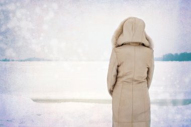 Kadın kışın donmuş nehrin yanında