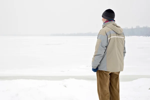 Hombre cerca del río congelado en invierno — Foto de Stock