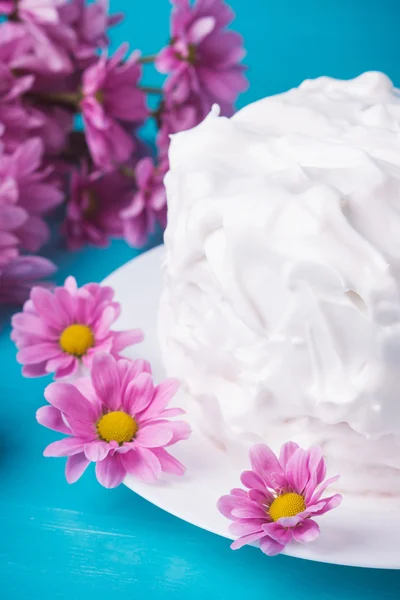 Белый кремовый торт с цветами на синем фоне деревянные — стоковое фото