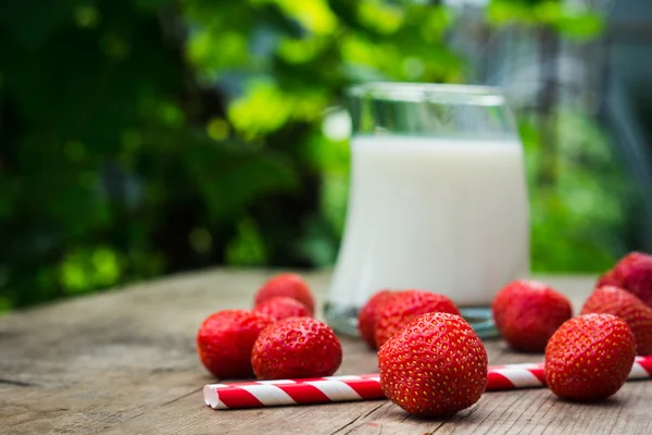 Glas melk en rijpe aardbeien — Stockfoto