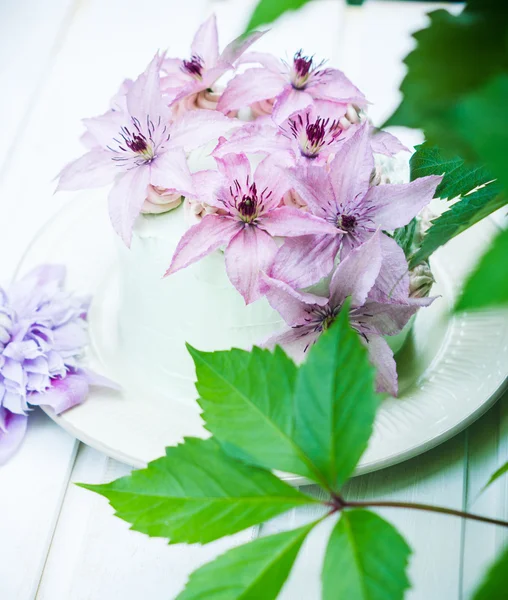 Pastel cremoso con flores de clematis en la mesa de madera — Foto de Stock