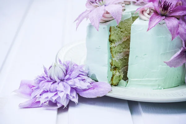 Pastel cremoso con flores de clematis en la mesa de madera — Foto de Stock