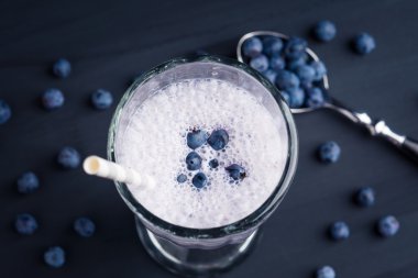 Yaban mersini milkshake ahşap arka plan üzerinde