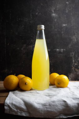 Geleneksel İtalyan limonata limonçellosu koyu kırsal arka planda. Seçici odak.