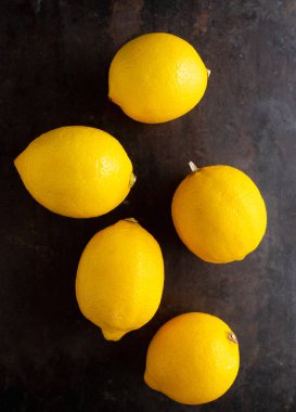 Köy arka planında olgun parlak limonlar. Seçici odaklanma. Sığ alan derinliği.