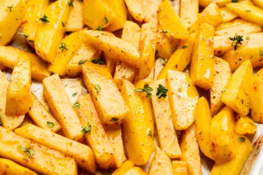 Tavada baharat ve bitkilerle dilimlenmiş çiğ patates pişirmeye hazır. Seçici odaklanma. Sığ alan derinliği.