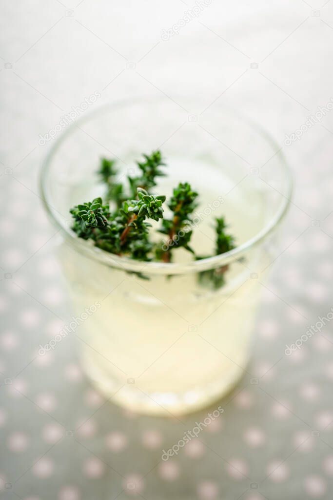 Freshly making gin based old fashioned cocktail with lemon juice and thyme. Selective focus. Shallow depth of field.