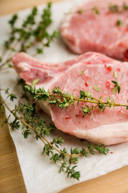 Köy arka planında kekik ve baharatlı çiğ domuz eti. Seçici odaklanma. Sığ alan derinliği.