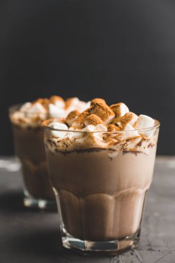 Eski moda bardakta kremalı ve tarçınlı sıcak çikolata içeceği. Seçici odak.