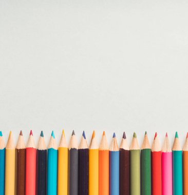 Beyaz bir kağıt üzerinde renkli kalemler. Seçici odaklanma. Arkaplan ve dokular.