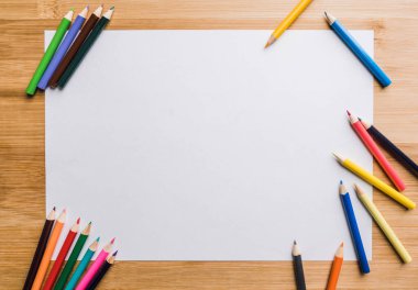 Beyaz bir kağıt üzerinde renkli kalemler. Seçici odaklanma. Arkaplan ve dokular.