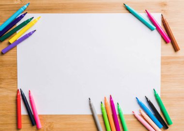 Beyaz kağıt üzerinde renkli kalemler var. Seçici odaklanma. Arkaplan ve dokular.