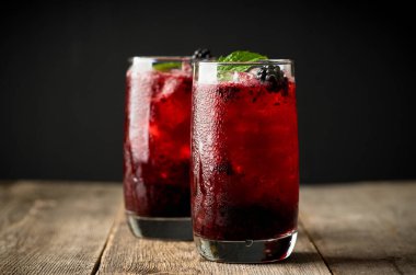 Kırsal ahşap arka planda ezilmiş buzlu böğürtlen kokteyli. Seçici odaklanma. Sığ alan derinliği.