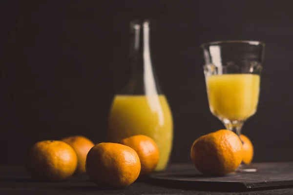 Oranges and juice on the dark background — Stock Photo, Image