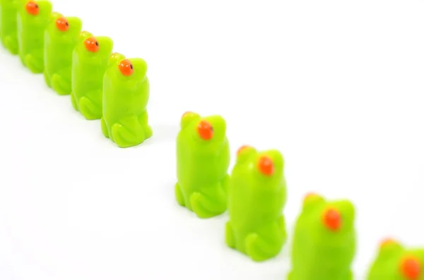 Peloton groene speelgoed kikkers. — Stockfoto