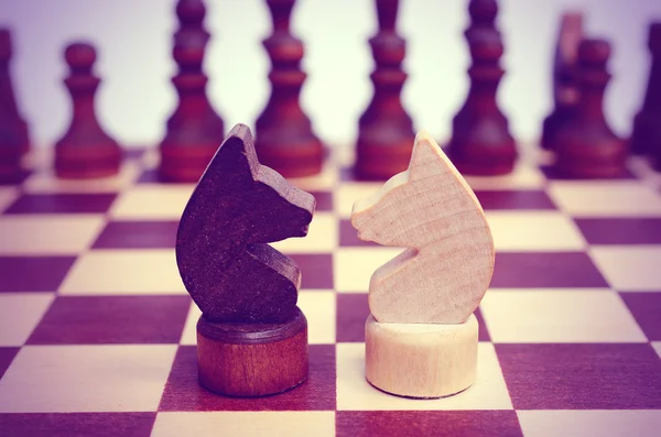 Dois cavaleiros num tabuleiro de xadrez. Confronto . — Fotografia de Stock